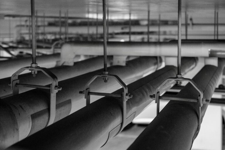 Black and white photo of industrial pipes and fittings, captured in a production facility.